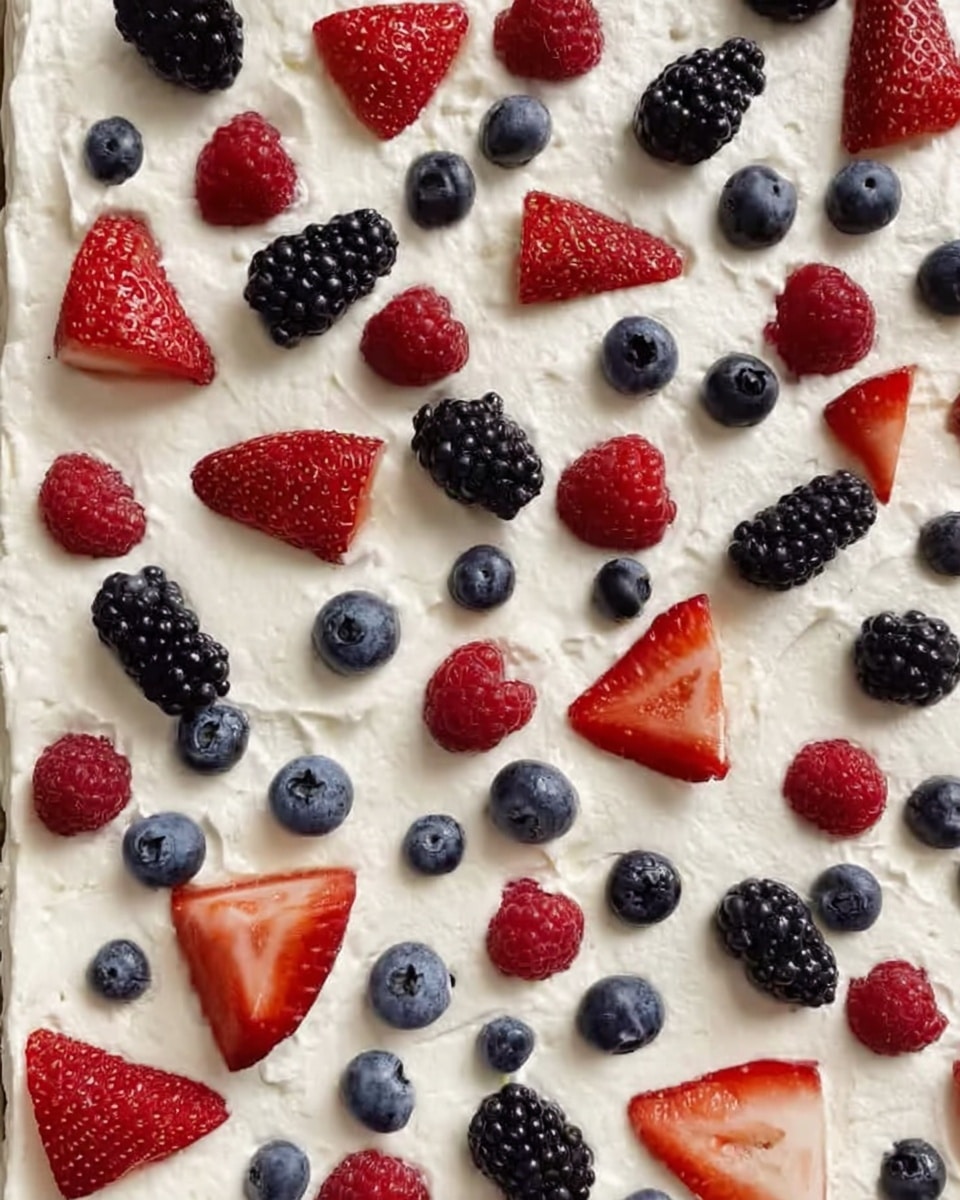 The image shows a flat dessert with one layer of thick white cream spread evenly on a flat surface. On top of the cream, there are small pieces of red strawberries, round blue blueberries, black blackberries, and red raspberries scattered all over evenly. The strawberries are cut into halves and quarters, while the other berries are whole. The background is a white marbled texture. photo taken with an iphone --ar 4:5 --v 7