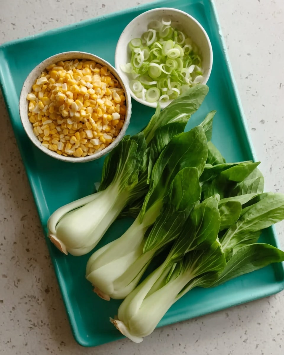 The image shows a white marbled surface with a bright teal tray holding fresh ingredients. On the tray, there is a small white bowl filled with yellow corn kernels at the bottom left. Next to it on a white small dish are long, thin, green onion slices gathered neatly. Beside the sliced green onions lie two fresh baby bok choy with white bulbs and bright green leaves. The textures are fresh and vibrant, emphasizing the natural colors of the vegetables. photo taken with an iphone --ar 4:5 --v 7