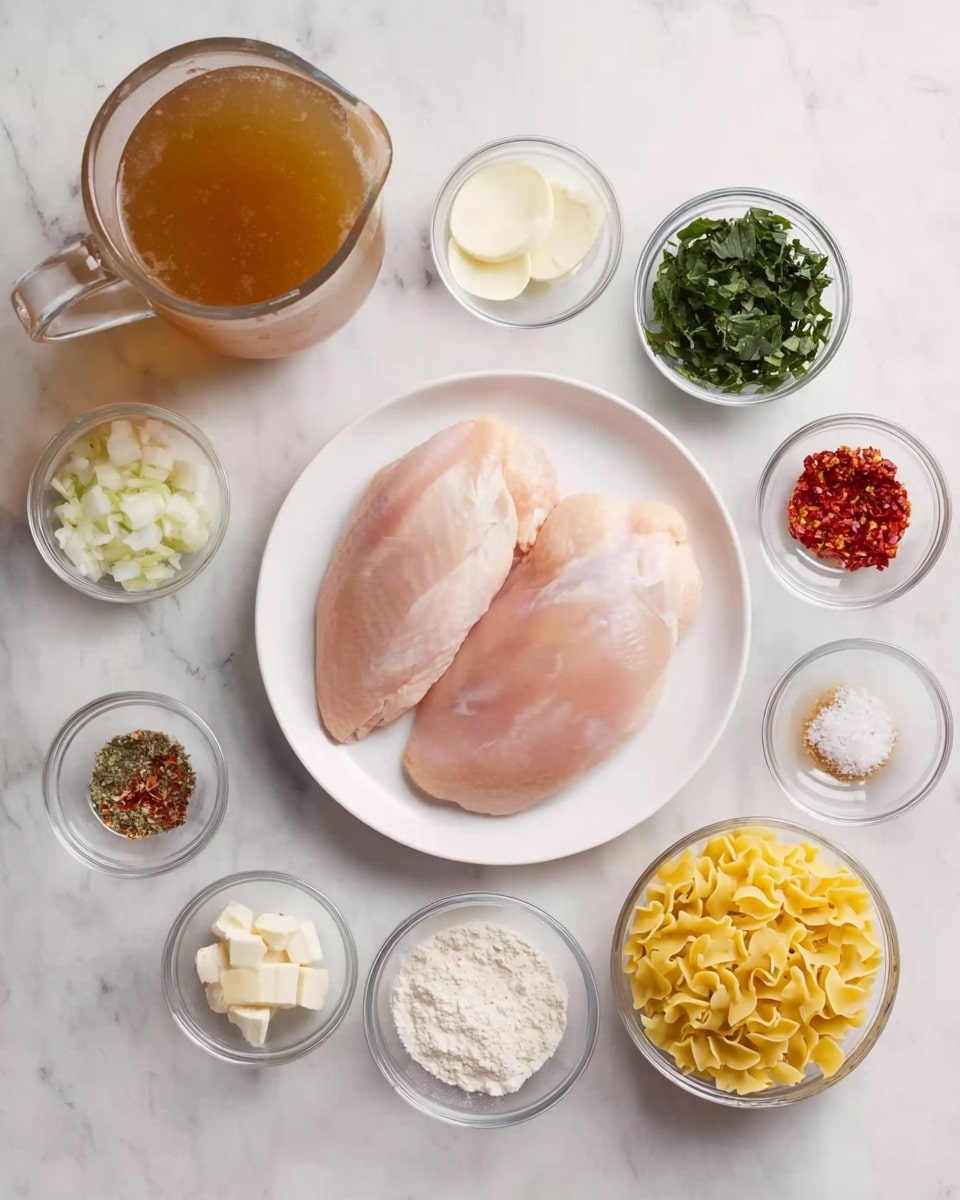 A white round plate holds two large, raw chicken pieces with a smooth pale pink surface, placed near the center. Around the plate are several small clear glass bowls arranged symmetrically on a white marbled surface, each containing different ingredients: yellow pasta with ruffled edges, chopped green leafy vegetables, white diced onions, minced garlic, small dollops of butter, sun-dried tomatoes, mixed dried herbs, salt and pepper, red chili flakes, white powdery flour, and a small glass jug with a light cream liquid. There is a large clear measuring jug filled with brown broth near the top left. The scene is neatly organized with a bright, clean look. photo taken with an iphone --ar 4:5 --v 7