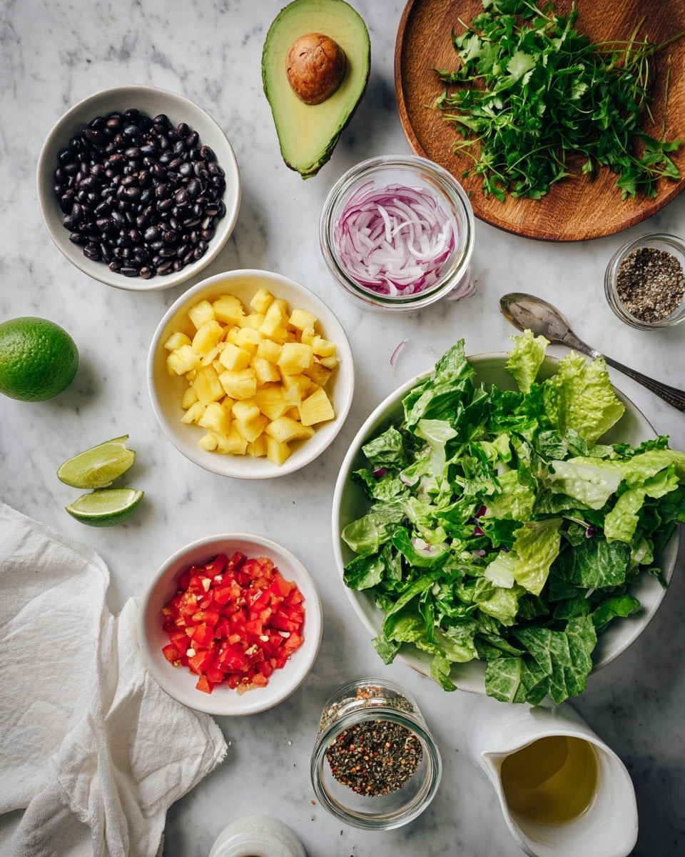 The image shows an overhead view of a food preparation scene on a white marbled surface. In the center, there is a white bowl filled with mixed green lettuce leaves that look fresh and leafy. Around it, there are several small white bowls and containers: one with black beans, one with bright yellow pineapple chunks, one with finely chopped red bell peppers, and one with sesame seeds. A glass jar with thinly sliced red onions and a small jar of mixed pepper spices are nearby. Half of an avocado with a brown seed is placed near the top center. There is a wooden plate with fresh green herbs on the right side, and a small white cup with a spoon and some oil sits near the bottom left. A wedge of lime and a white cloth napkin are also visible on the marble surface. photo taken with an iphone --ar 4:5 --v 7
