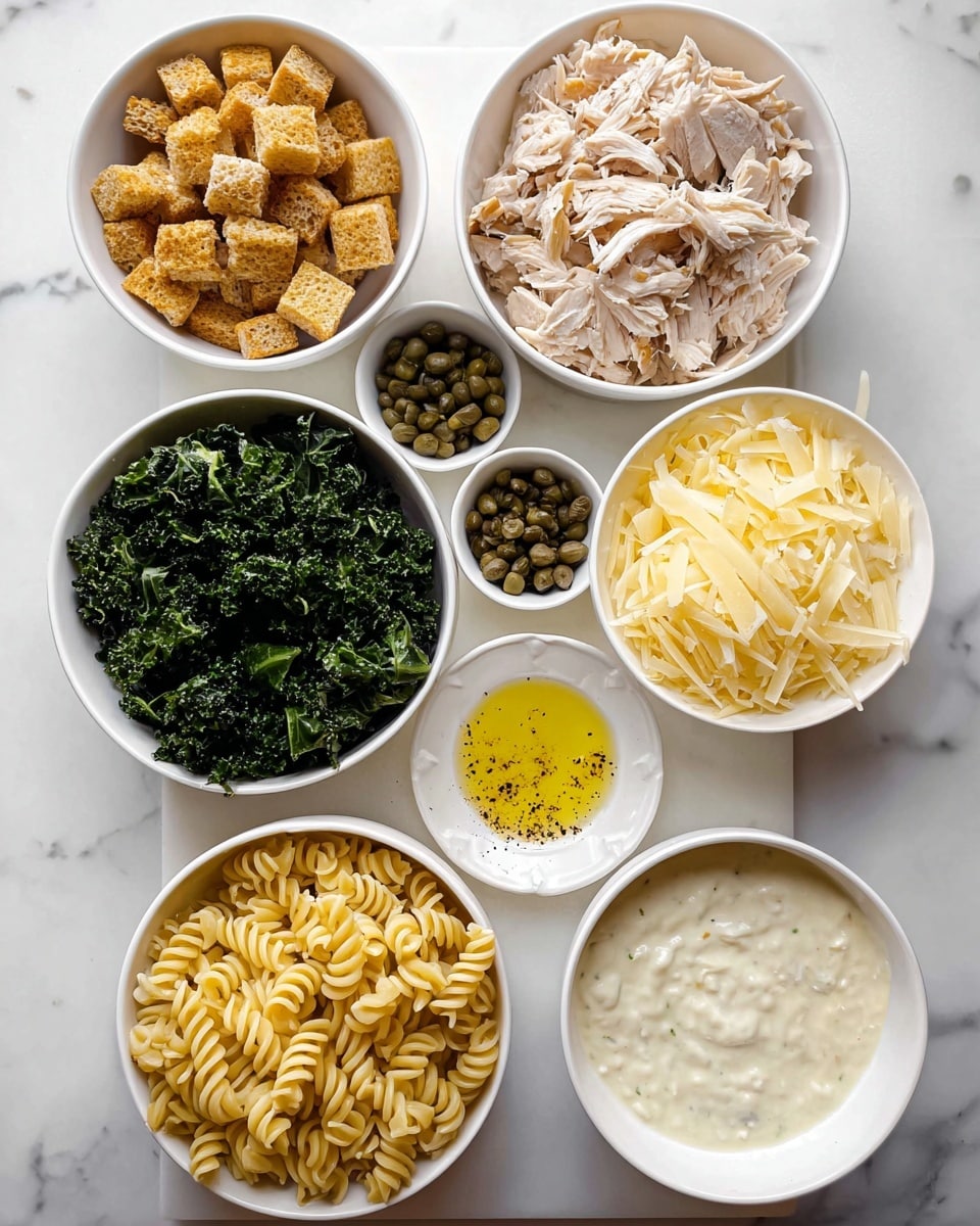 The image shows seven white bowls arranged on a white marbled surface, each holding a different ingredient. Starting from the bottom right, a bowl is filled with cooked pale yellow rotini pasta. Above it, a bowl contains small, golden brown crunchy croutons. Next to the croutons is a bowl of dark green chopped kale. Above the kale, there is a bowl of shredded light brown cooked chicken. To the right of the chicken, another bowl is filled with thin pale yellow cheese shavings. Above the cheese, a small bowl holds small dark green capers, and next to it on a white saucer is a small container of oil with some yellow grated zest. To the right of the capers is a bowl with thick creamy white dressing dotted with black pepper. Photo taken with an iphone --ar 4:5 --v 7