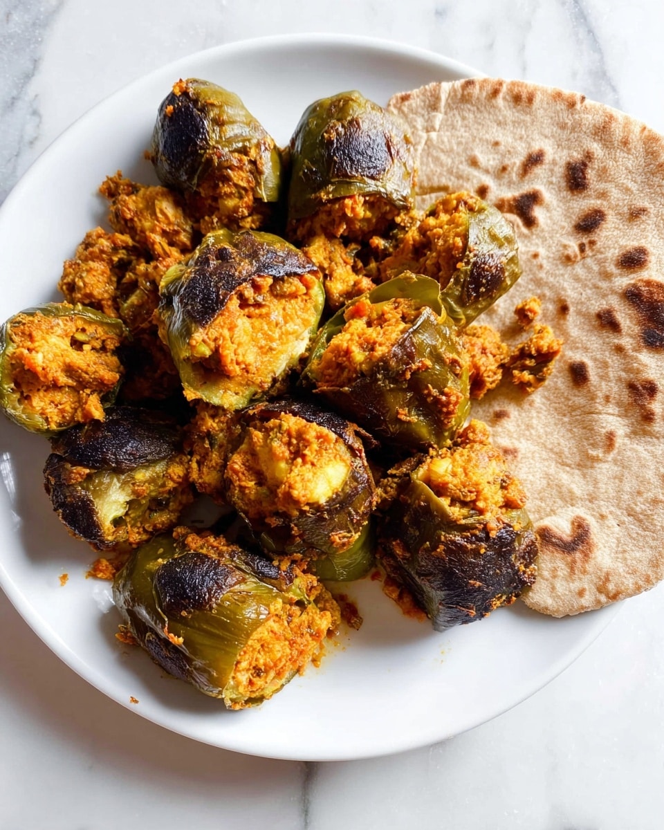 A white plate sits on a white marbled surface, holding several stuffed vegetables with dark green outer skins that are slightly charred and cracked to show a soft, orange filling inside. The stuffed vegetables are arranged in a loose group toward the top and center of the plate. At the bottom edge of the plate rests a light brown flatbread with some darker toasted spots, partially overlapping the vegetables. The overall image shows a warm, rustic dish with textured stuffing spilling out from the vegetable shells. photo taken with an iphone --ar 4:5 --v 7