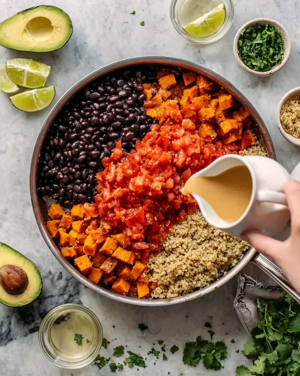 A metal pan on a white marbled surface holds four main layers: cooked black beans on the lower left, bright red diced tomatoes on the upper half, and light brown quinoa on the lower right. The pan has diced orange sweet potatoes scattered under the top layers, adding texture. A woman's hand pours a light beige liquid from a small white pitcher into the pan from the right side. Around the pan, there are halves of green avocados, wedges of lime, scattered green cilantro leaves, and small bowls with chopped cilantro and a clear liquid. Photo taken with an iphone --ar 4:5 --v 7