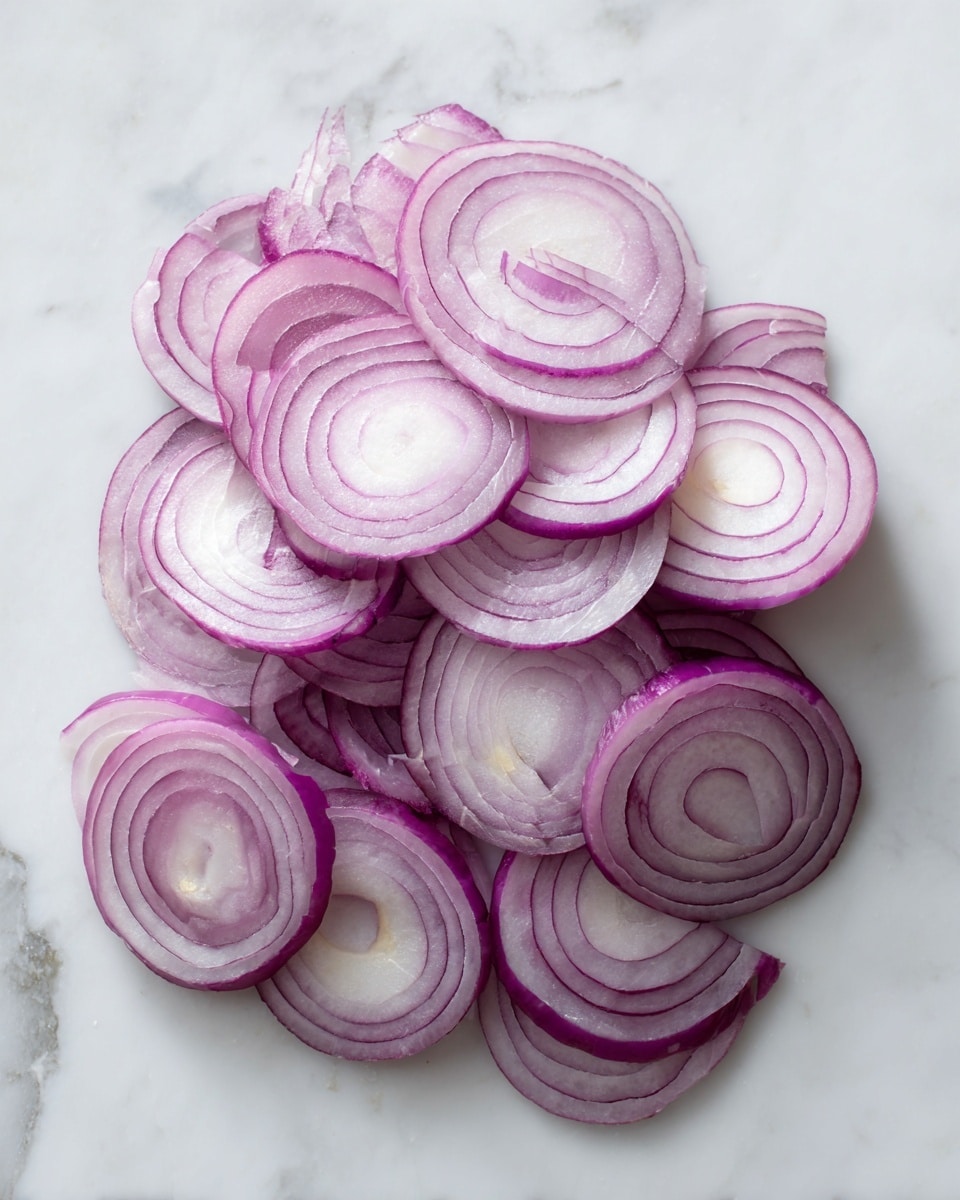 Thin slices of red onion are spread loosely on a white marbled surface. The onion slices are layered in a way that shows their circular shape and semi-translucent pale purple color with darker purple edges. The overall shape forms a small pile with varying thickness as some slices overlap, creating a textured look. photo taken with an iphone --ar 4:5 --v 7