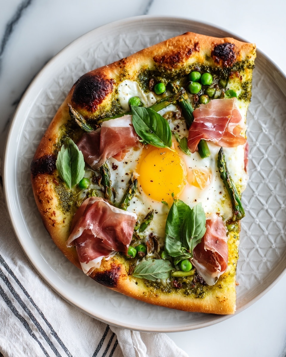 A round pizza with one layer of golden brown crust with some charred spots, spread evenly with a green pesto sauce. In the center, a sunny yellow fried egg sits on a white egg white base, lightly seasoned with black pepper. Around the egg, there are bright green peas and fresh basil leaves scattered, along with thin, light pink slices of prosciutto draped softly over the pizza. The pizza is placed on a white plate with a textured light grey rim, all set on a white marbled surface with some loose basil leaves nearby and a light striped cloth to the top right. photo taken with an iphone --ar 4:5 --v 7