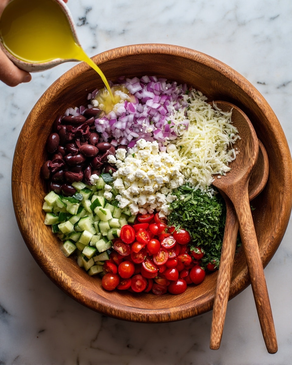 A wooden bowl filled with six distinct layers of fresh salad ingredients arranged side by side: chopped dark purple olives at the top left, finely diced red onions to the right of the olives, small white crumbles of cheese to the right of the onions, green chopped herbs running horizontally below the cheese and onions, shredded white cheese beneath the herbs, diced green cucumbers in the top left corner, and halved red cherry tomatoes below the cucumbers. Two wooden spoons rest on the right side of the bowl on a white marbled surface, with a woman's hand pouring light yellow dressing into the bowl from the top left corner. The photo taken with an iphone --ar 4:5 --v 7