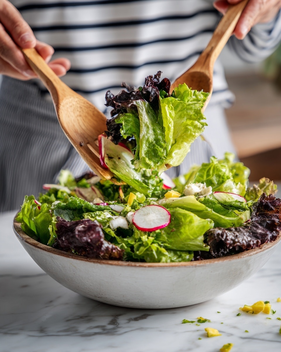 A fresh salad with two main layers: the bottom layer has dark purple leafy greens and small chopped pieces of yellow bell pepper scattered around; the upper layer has bigger light green lettuce leaves, sliced radishes with white and red edges, and some white chunks that look like cheese or egg. The salad is being lifted by two wooden forks held by a woman's hand, with the leaves and ingredients showing fresh and crisp textures. The scene is set on a white marbled surface with a person wearing a striped shirt blurred in the background. photo taken with an iphone --ar 4:5 --v 7