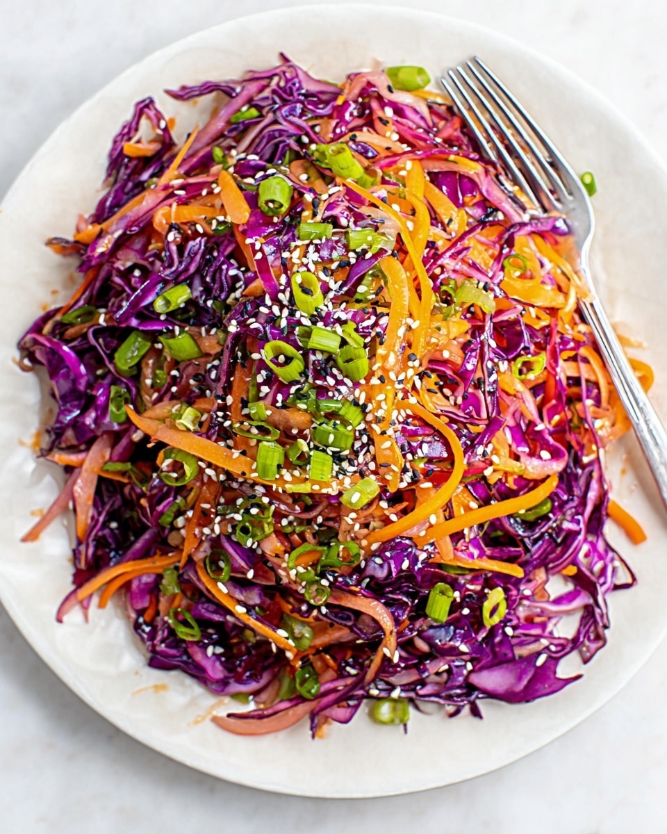The image shows a colorful salad served on a white plate, placed on a white marbled surface. The salad has three main layers: the first layer is made of thin, sliced purple cabbage pieces spread densely across the plate with a slightly shiny texture. The second layer consists of thin, orange carrot strips scattered evenly over the cabbage. The third layer is finely chopped green onions sprinkled on top, adding a fresh green color. White sesame seeds are lightly sprinkled throughout the salad, adding small specks of cream color. A silver fork is placed near the bottom right edge of the plate. The photo taken with an iphone --ar 4:5 --v 7