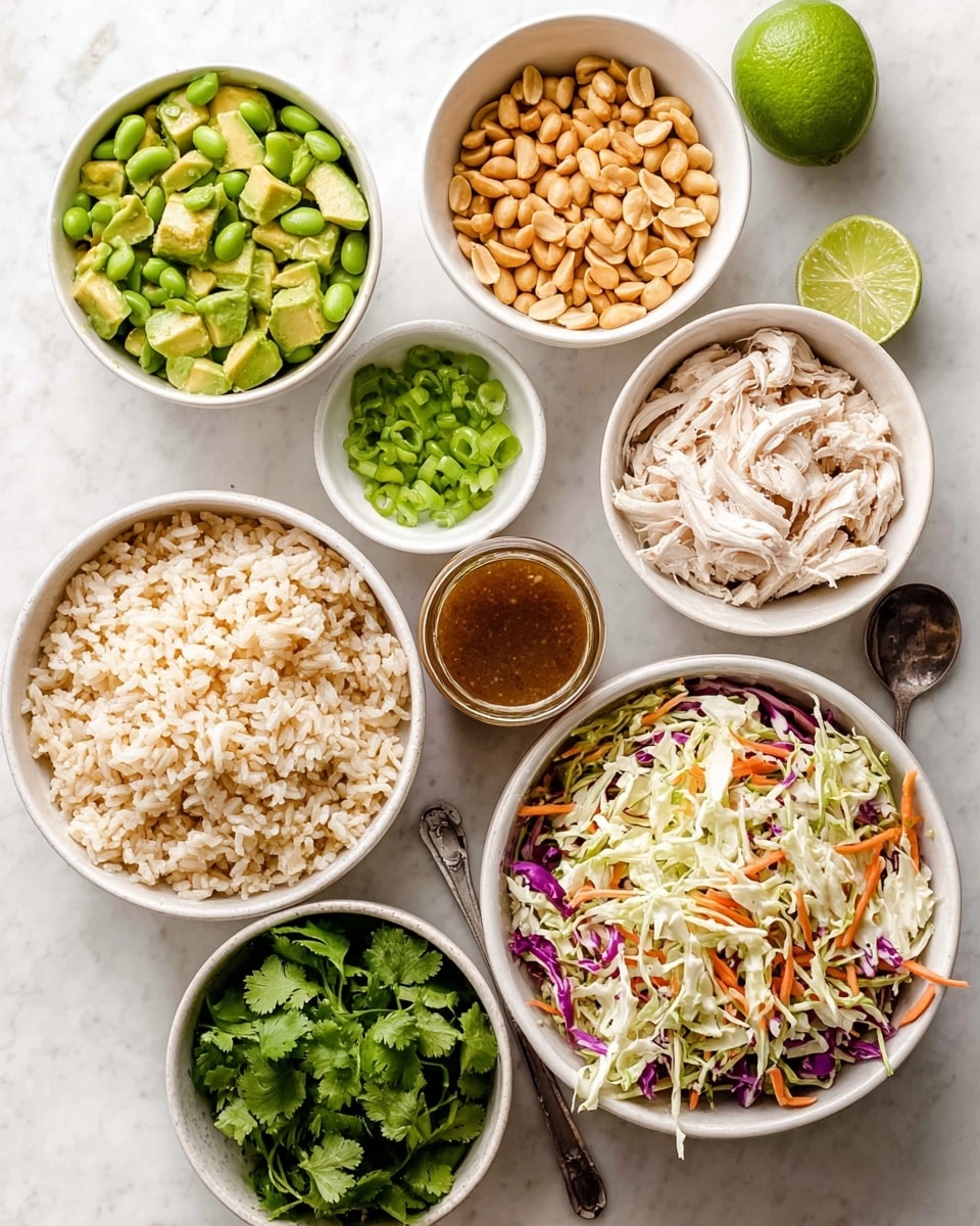 The image shows eight white bowls with different fresh ingredients arranged on a white marbled surface. Starting from the top left, there is a bowl with green, chunky avocado pieces. To its right, a bowl full of bright green edamame beans. Below the avocado, a small bowl with thinly sliced green onions, and next to that, a small bowl filled with golden roasted peanuts. To the right of the peanuts, a bowl holds shredded white chicken. Next to the chicken, a bowl piled with cooked rice with a mix of white and golden brown grains. At the bottom right, there is a large bowl filled with a colorful coleslaw mix of shredded white cabbage, purple cabbage, and thin carrot strips. Next to it, a small bowl with fresh green cilantro leaves. Lastly, a jar of brown dressing with a spoon sits near a whole lime and a lime half. The image is well-lit and balanced, photo taken with an iphone --ar 4:5 --v 7