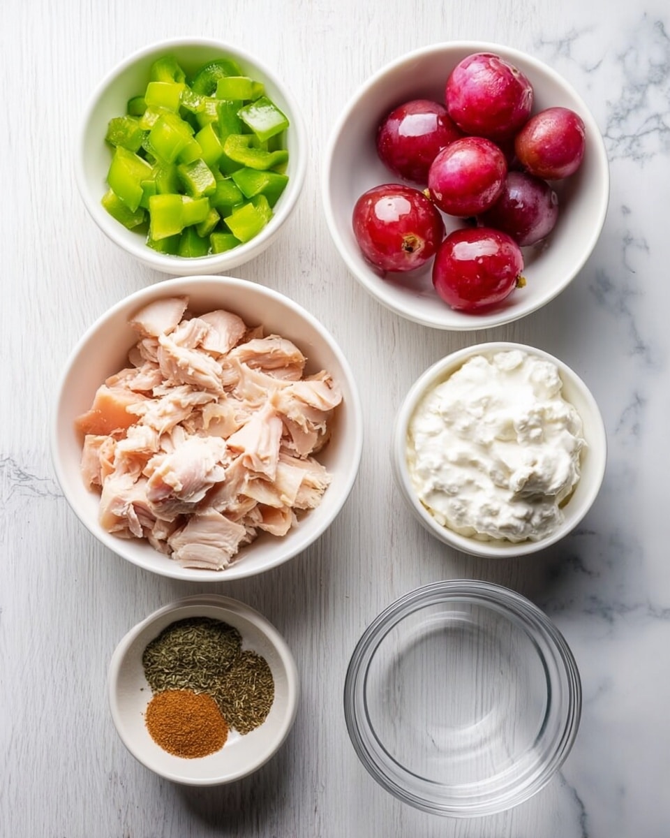 The image shows six small white bowls placed on a white marbled surface, each containing different ingredients for a recipe. In the center is a bowl filled with torn chunks of cooked light pink chicken. Above it, a bowl holds halved red grapes with a shiny, smooth texture. To the left of the grapes, a bowl contains chopped green bell peppers in small square pieces. Below the chicken, another bowl is filled with a creamy white substance, likely yogurt or sour cream. To the right of the grapes, a smaller bowl holds two piles of dried spices, one dark green and the other light brown. Finally, below the creamy bowl and empty space is a completely clear empty bowl. The overall arrangement is neat, displayed on the white marbled surface. Photo taken with an iphone --ar 4:5 --v 7
