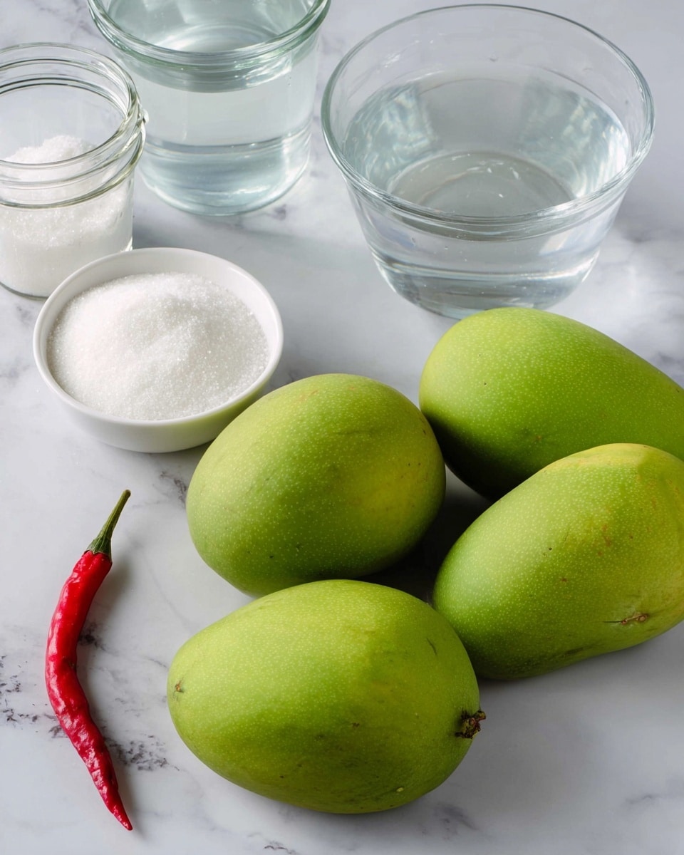 The image shows three whole green mangoes placed on a white marbled surface. To the upper left of the mangoes, there is a small white bowl full of white granulated sugar, and next to it is a small clear bowl with coarse white salt. Behind these bowls, there is a clear glass bowl filled with water and two empty glass jars with white lids. At the bottom left corner of the image, there is a single red chili pepper lying on the white marbled surface. photo taken with an iphone --ar 4:5 --v 7